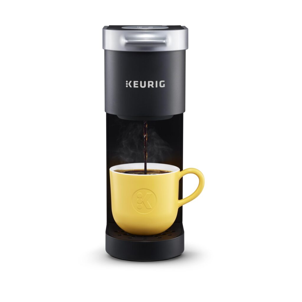 Coffee maker brewing into yellow mug.