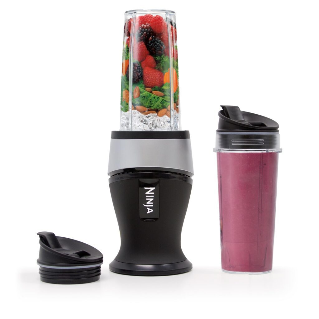 Blender with fruits and smoothie cup.