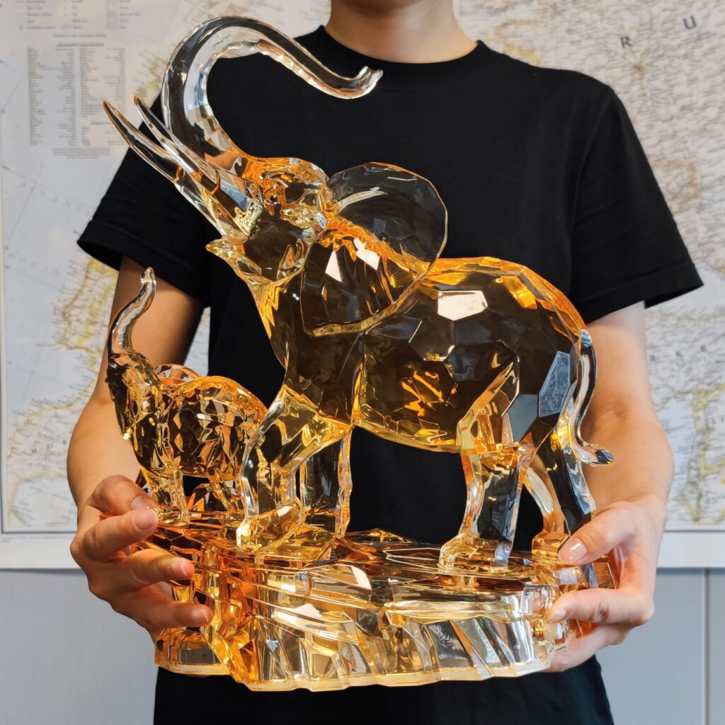 Person holding crystal elephant figurine.