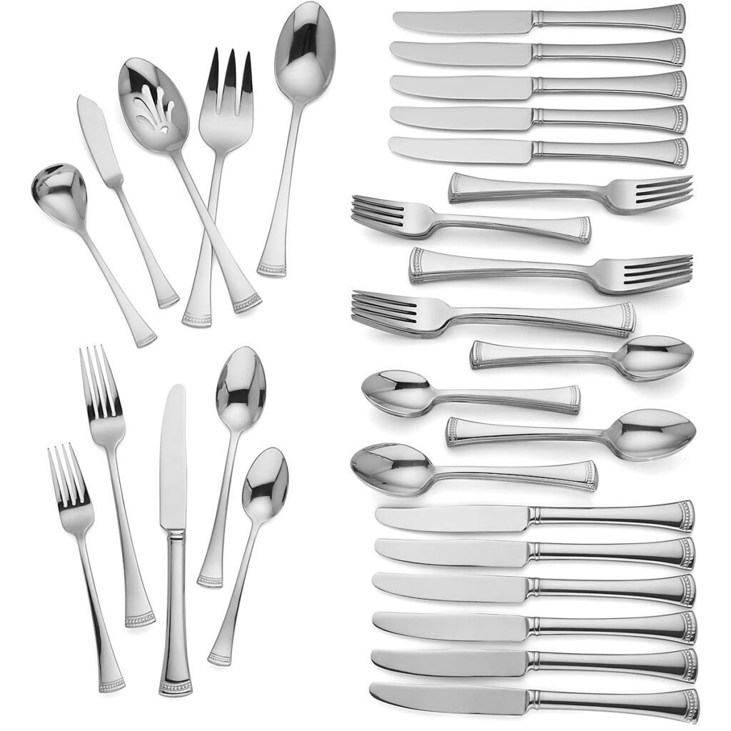 Silver cutlery set arranged on white background.